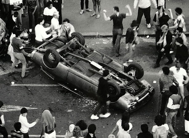 Concertgoers overturn a car during the Queen St riot, 1984