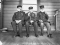 Three men sitting on porch