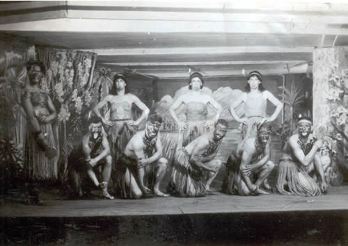 POWs dressed as Maori warriors and women dancing