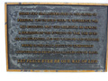 Close up view of brass plaque with writing on it.