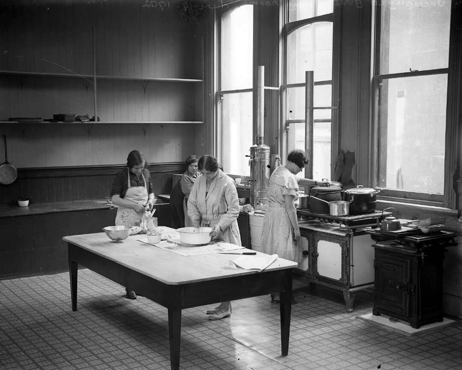 Four women in a kitchen preparing food as part of the Women's unemployment Bureau relief efforts.