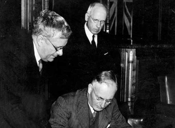 Australian Prime Minister John Curtin signs the Canberra Pact, watched by Australian Minister of External Affairs H.V. Evatt