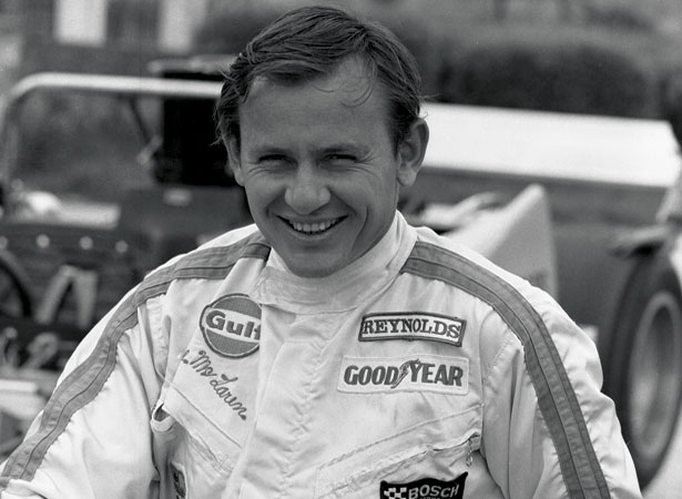 A smiling Bruce McLaren in his racing overalls