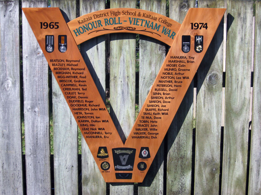 Wooden V-shaped plaque attached to fence with list of names in black text