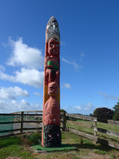 Red carved Māori pouwhenua (land post)