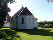 Small wooden church building positioned on grass area