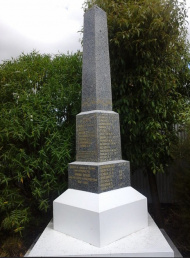 Photograph of an obelisk shaped marble memorial with names listed on each side