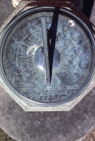 Bronze sundial featuring inscriptions of words, numbers, and arrows