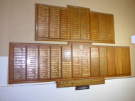 Wooden plaques fixed on a wall with lists of names in gold lettering