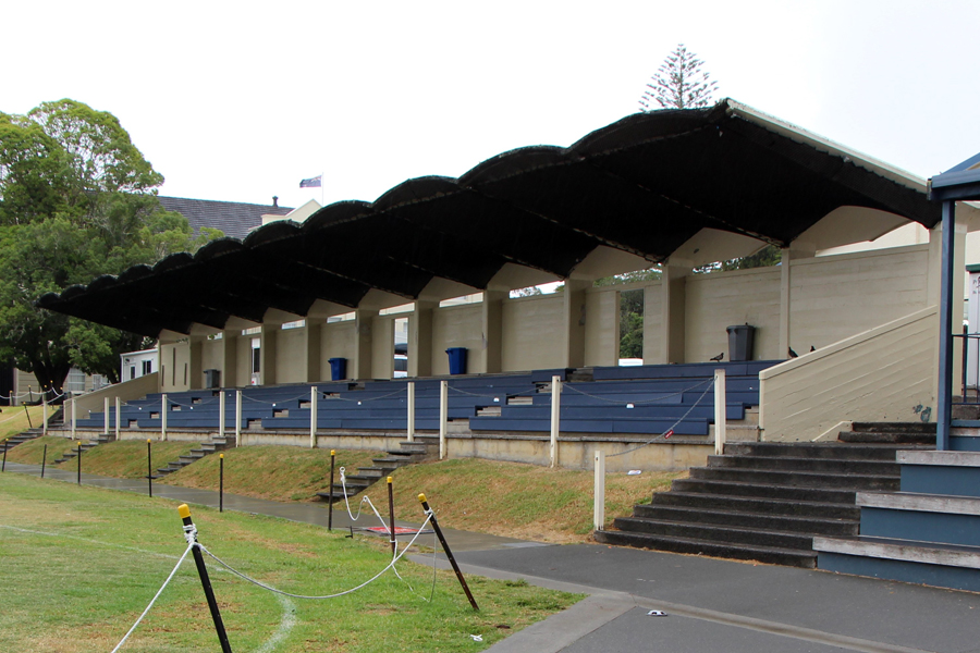 Sports grandstand at the side of roped-off grass sports field