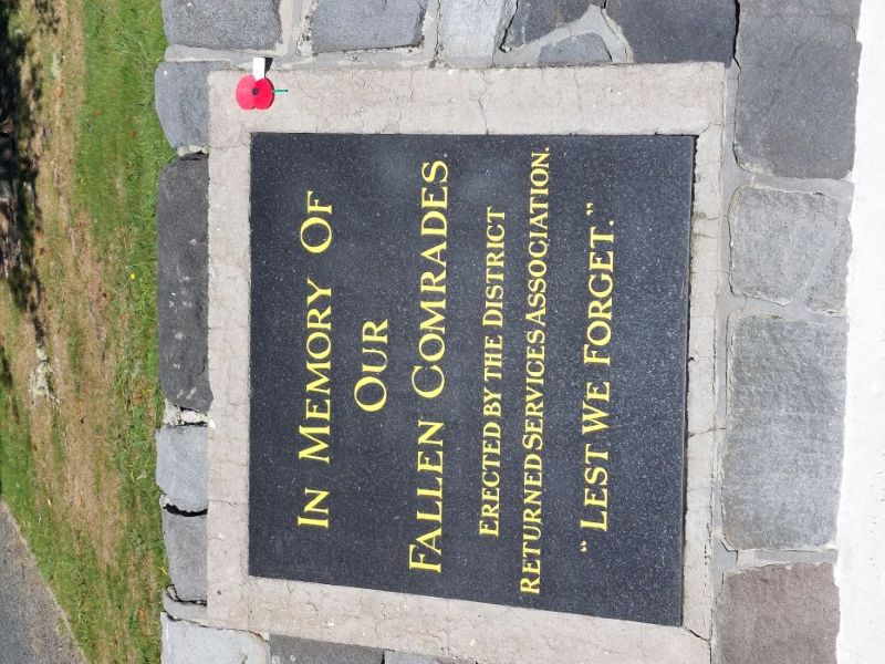Black plaque set into ground with gold writing