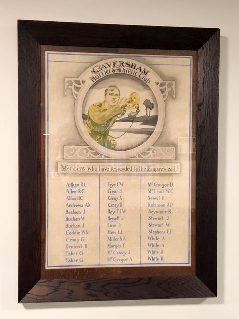 Three columns of names underneath picture of soldier with bugle inside glass frame.