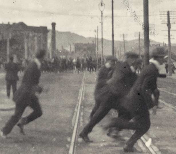 People running on the street from men on mounted horses