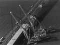 Cranes floating on harbour lifting new lanes onto the bridge