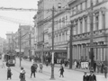 Historical photo of city street with trams and crowded pavements