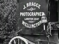 Side of wagon with 'James Bragge photography Wellington' sign
