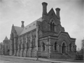 Two-story stone building beside empty dirt road 