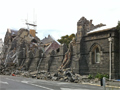 Collapsed wall of stone building with police emergency tape stopping people getting too close