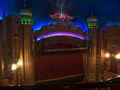 Purple and green lights over stage with curtains
