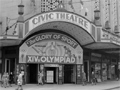 Civic Theatre entrance on corner of street with large advertising sign for the 14th Olympiad