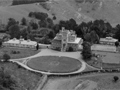 Looking down on castle with large circular lawn and harbour in background