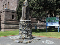 Stone memorial of figure turning their back.