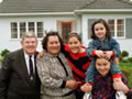 Family pose in front of house