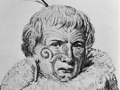 Man in traditional cloak with tattooed and feather in his hair