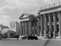 Street scene with bank buildings in centre and war memorial to the left.