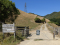 Sign for 'Old Coach Road next to closed gate over metal road