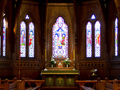 Interior of front of church showing organ, pews and stained glass windows