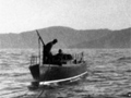 Men on whaling boat pulling a whale