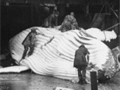 Men cutting up whale in a shed by the beach