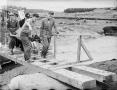 Men carrying body over bridge