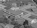 Aerial view of veteran's home and surrounding buildings and grounds. Set in urban area.
