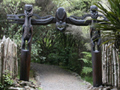 Carved gateway with wooden fence on each site and over stone path