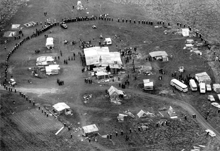 Aerial view of police cordon around protesters and buildings prior to their removal from Bastion Point in Auckland, 1978