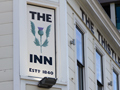 Sign with 'The Inn' with image of thistle between the words