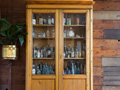 Wooden cabinet filled with old bottles inside pub