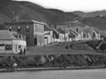 Historic photo of inn taken from the harbour with dinghy in foreground