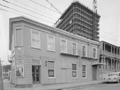 Inn with tall building under scaffolding in background