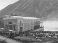 Historical images showing large crowd gathered next to dam