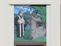 Close-up of front of building with mural of missionary showing the Bible to a Māori family and sign, 'Petone Settlers Museum'