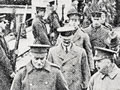 High-ranking soldiers and men in top hats on wharf with railway lines, flanked by soldiers standing to attention. Caption says, 'His Excellency the Govrrnor, the Earl of Liverpool, in company with the Minister for Defence, Colonel James Allen. Arriving at Port Chalmers to inspect the hospital ship Marama'.