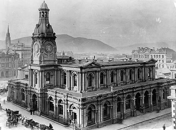 Original University of Otago building with horse-drawn carts in front.