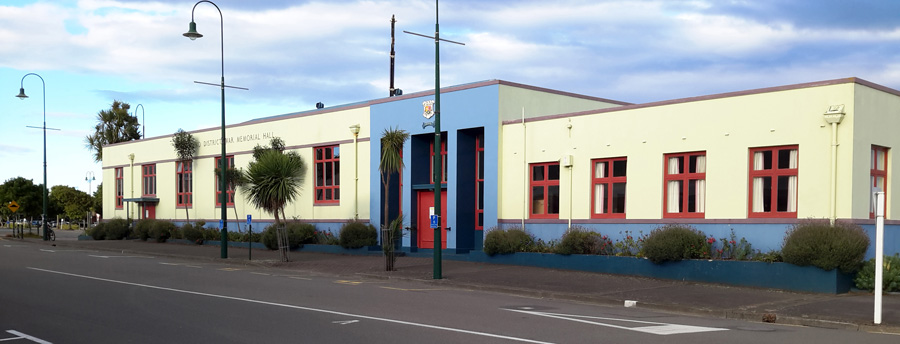 Profile view of cream and blue coloured building. Photographed from across a road.