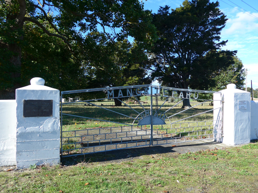 Cast iron gates inlaid with the word 'Mangateparu' between two white pillars