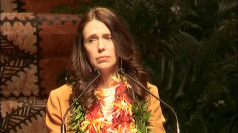 Prime Minister Jacinda Ardern with wreath of flowers and leaves around her neck