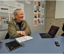 Smiling middle-aged man sitting at table with laptop open 