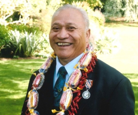 Smiling man in suit with lei around his neck